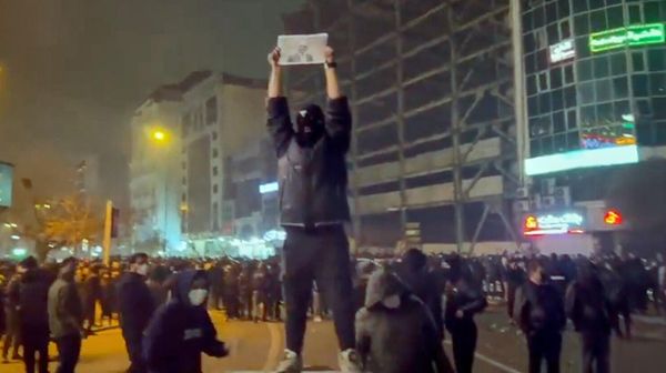 Кадр из видео с демонстрантом в маске, держащий фотографию наследного принца Ирана Резы Пахлави во время протеста (9 января 2026). Тегеран - Sputnik Армения