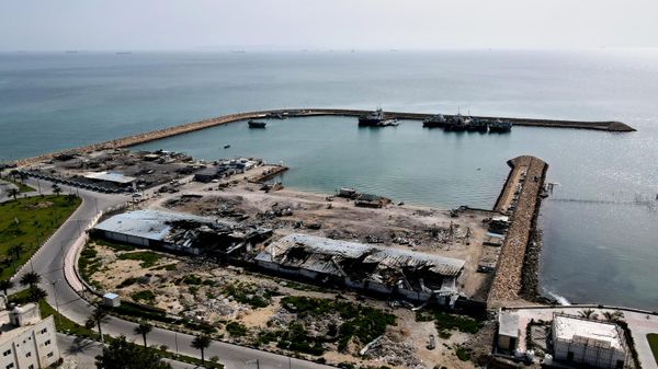 На фоне кораблей в Ормузском проливе видны повреждения на рыболовецком пирсе в порту острова Кешм, Иран - Sputnik Армения