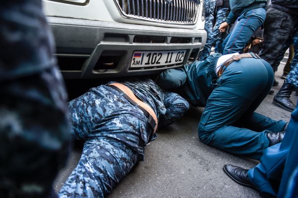 Полицейские пытаются вытащить активиста из-под автомобиля полиции - Sputnik Армения