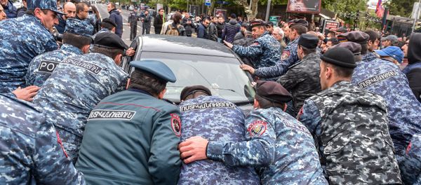 Полицейские выводят автомобиль с проезжей части, которая парализовала движение на проспекте Маштоца (21 апреля 2018). Ереван - Sputnik Армения