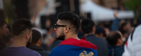 Герб Армении, изображенный на флаге Армении, обернутом гражданином Армении. - Sputnik Армения