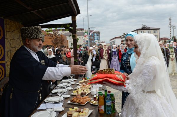 Невеста принимает подарок от гостей во время церемонии массового бракосочетания 200 пар, проводимой в рамках празднования 200-летия города (5 октября 2018). Грозный Невеста принимает подарок от гостей во время церемонии массового бракосочетания 200 пар, проводимой в рамках празднования 200-летия города (5 октября 2018). Грозный - Sputnik Армения