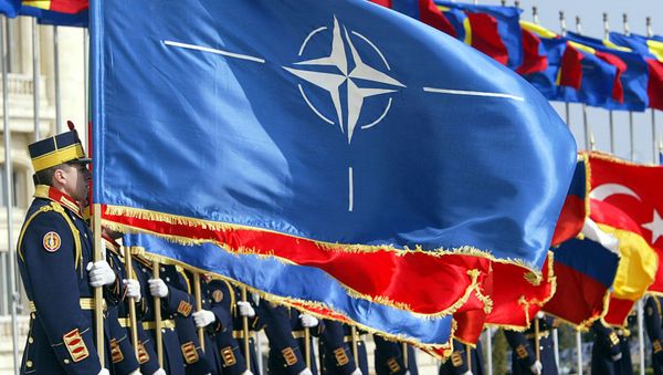 Солдаты румынской армии из гвардейского полка держат флаги стран-членов НАТО во время церемонии поднятия флага НАТО (2 апреля 2004). Бухарест - Sputnik Армения