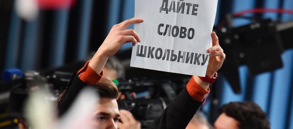 Табличка в руках журналиста во время ежегодной большой пресс-конференции президента России Владимира Путина (20 декабря 2018). Москвa - Sputnik Армения