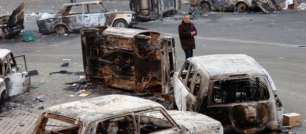 Мужчина среди сожженных автомобилей, оставленных после ночных беспорядков (2 марта 2008). Еревaн - Sputnik Армения