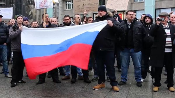СПУТНИК_Кельнцы с флагами РФ вышли на митинг из-за инцидента с девочкой в Берлине - Sputnik Արմենիա