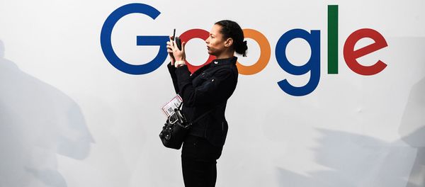 Женщина с двумя смартфонами перед логотипом американской многонациональной технологической и интернет-компании Google (16 мая 2019). Париж - Sputnik Արմենիա