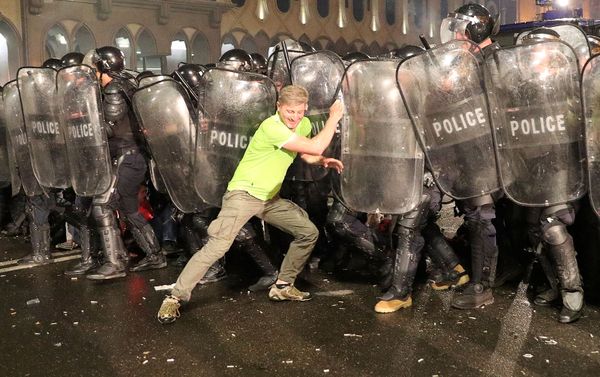 Протестующий опирается на щиты ОМОНа во время митинга против визита российского депутата Грузию (21 июня 2019). Тбилиси Протестующий опирается на щиты ОМОНа во время митинга против визита российского депутата Грузию (21 июня 2019). Тбилиси - Sputnik Армения