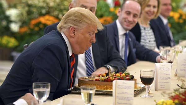 Президент США Дональд Трамп задувает свечу на торте в свой день рождения во время встречи с премьер-министром Сингапура Ли Сянлуном - Sputnik Армения