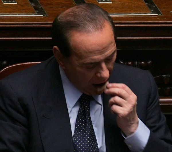 Премьер Италии Сильвио Берлускони ест кусочек шоколада в Риме, 2005 год - Sputnik Армения