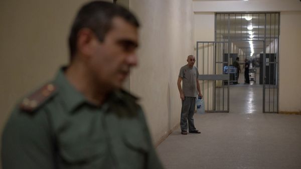 Сотрудник УИУ Армавир наблюдает за интервью заместителя начальника Геворга Симоняна во время международного шахматного турнира среди заключенных (5 августа 2019). Армавирская область - Sputnik Արմենիա
