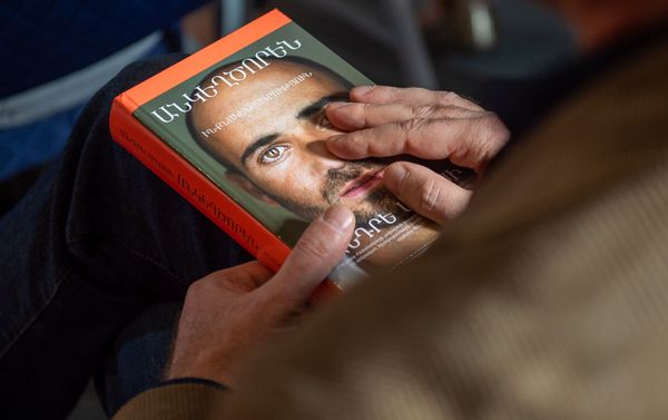 Переведенная на армянский язык книга Андре Агаси Откровенно в руках посетителя презентации (20 октября 2019). Еревaн - Sputnik Армения