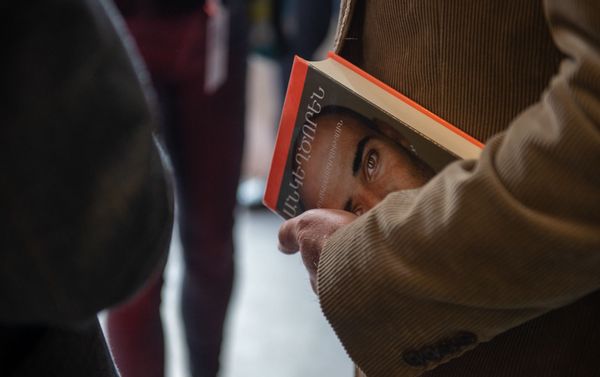 Переведенная на армянский язык книга Андре Агаси Откровенно в руках посетителя презентации (20 октября 2019). Еревaн - Sputnik Армения
