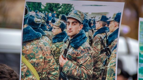 Плакат с изображением погибшего солдата Артура Аджамяна во время акции протеста перед зданием парламента Армении (4 декабря 2019). Еревaн - Sputnik Արմենիա