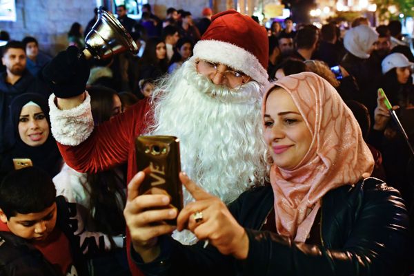 Женщина фотографируется с мужчиной в костюме Санта-Клауса на праздновании Рождества в сирийской Латакии Женщина фотографируется с мужчиной в костюме Санта-Клауса на праздновании Рождества в сирийской Латакии - Sputnik Армения