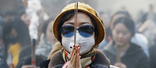 Женщина в маске и солнцезащитных очках во время молитвы в первый день Нового года в Пекине Женщина в маске и солнцезащитных очках во время молитвы в первый день Нового года в Пекине - Sputnik Արմենիա