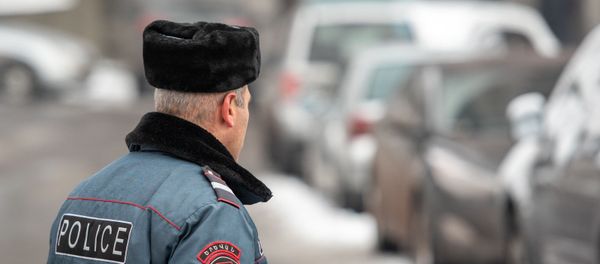 Сотрудник правоохранительных служб у дома, где обнаружено тело Георгия Кутояна (17 января 2020). Еревaн - Sputnik Արմենիա