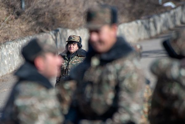 Сотрудница одной из воинских частей проходит мимо празднующих демобилизацию солдат Сотрудница одной из воинских частей проходит мимо празднующих демобилизацию солдат - Sputnik Армения