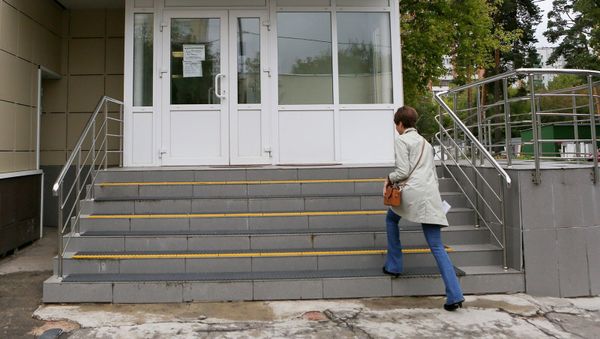 Женщина заходит в медицинский центр - Sputnik Армения