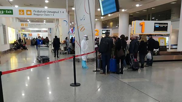 Сотрудник Минздрава в спецодежда встречает пассажиров из Ирана - Sputnik Армения