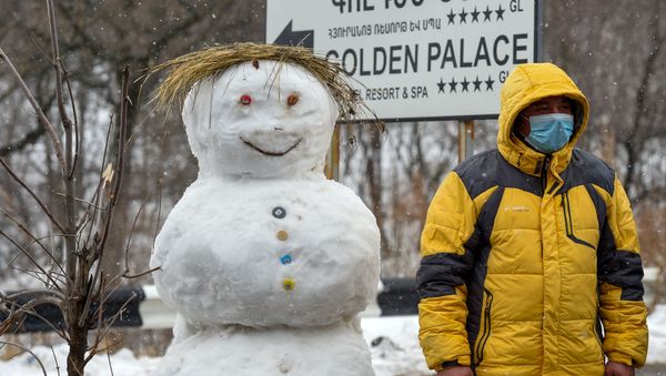 Мужчина на закрытом перекрестке, ведущим к отелю Golden Palace (1 марта 2020). Цахкадзор - Sputnik Армения