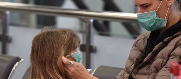 Женщина одевает медицинскую маску ребенку в аэропорту Шереметьево Женщина одевает медицинскую маску ребенку в аэропорту Шереметьево - Sputnik Արմենիա