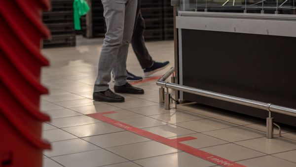 Разметки для соблюдения дистанции на полу в супермаркете Carrefour (27 марта 2020). Еревaн - Sputnik Армения