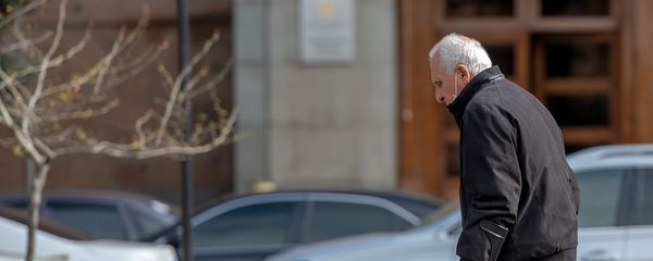 Пожилой человек в защитной маске проходит мимо правительственного здания (30 марта 2020). Еревaн - Sputnik Արմենիա