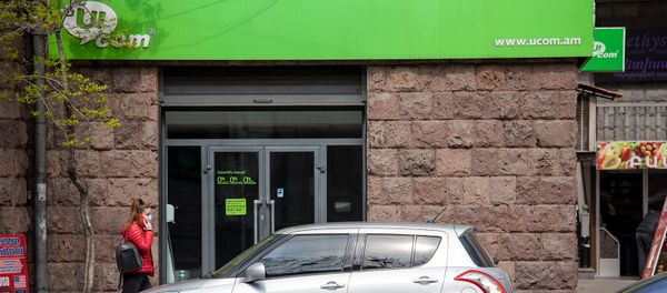 Девушка с телефоном проходит мимо офиса компании Ucom на проспекте Маштоца (10 апреля 2020). Еревaн - Sputnik Армения