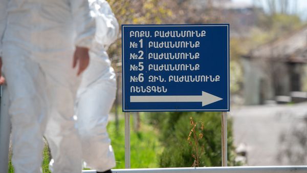 Сотрудники инфекционной больницы Норк проходят мимо указателя - Sputnik Армения