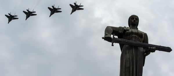 Истребители МиГ-29 пролетают над монументом Мать Армения в парке Победы на авиапараде (9 мая 2020). Еревaн - Sputnik Армения
