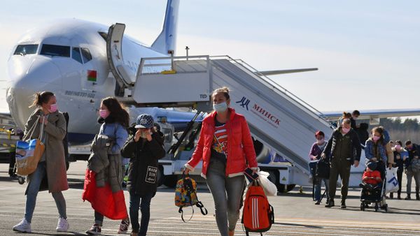 Пассажиры в защитных масках, после карантина в аэропорту Внуково из-за возвращения из стран Азиатско-Тихоокеанского региона, прибывшие в Минск благодаря специальному рейсу Белавиа (20 марта 2020). Минск - Sputnik Армения