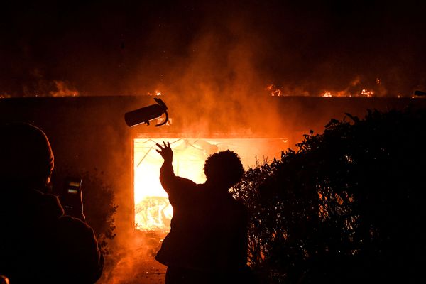 Протестующий бросает огнетушитель в горящее здание во время демонстрации в связи со смертью Джорджа Флойда, убитого полицейским (29 мая 2020). Миннеаполис Протестующий бросает огнетушитель в горящее здание во время демонстрации в связи со смертью Джорджа Флойда, убитого полицейским (29 мая 2020). Миннеаполис - Sputnik Армения