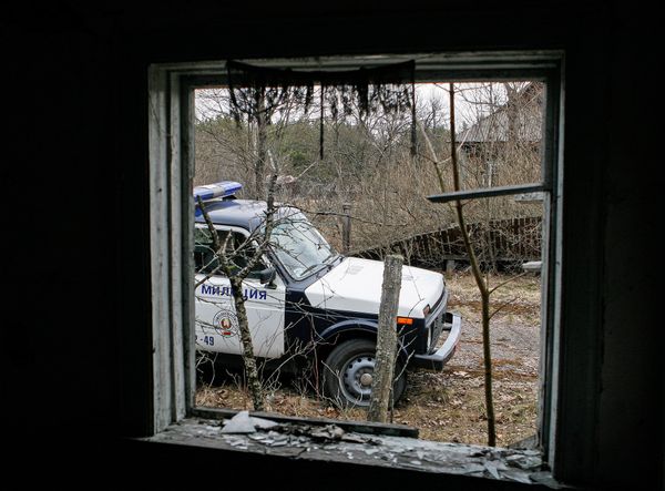 Вид на патрульную машину из брошенного дома в зоне отчуждения ЧАЭС. Сотрудники милиции обычно осматривают пустующие дома, нет ли там посторонних лиц. - Sputnik Армения