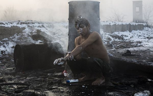 Беженцы в Белграде. Работа испанского фотографа Алехандро Мартинеса Велеса. На снимке: юноша на морозе моется у бочки, в которой греют воду беженцы из Афганистана и Пакистана, живущие на заброшенных складах рядом с Центральным вокзалом Белграда. Беженцы в Белграде. Работа испанского фотографа Алехандро Мартинеса Велеса. На снимке: юноша на морозе моется у бочки, в которой греют воду беженцы из Афганистана и Пакистана, живущие на заброшенных складах рядом с Центральным вокзалом Белграда. - Sputnik Армения
